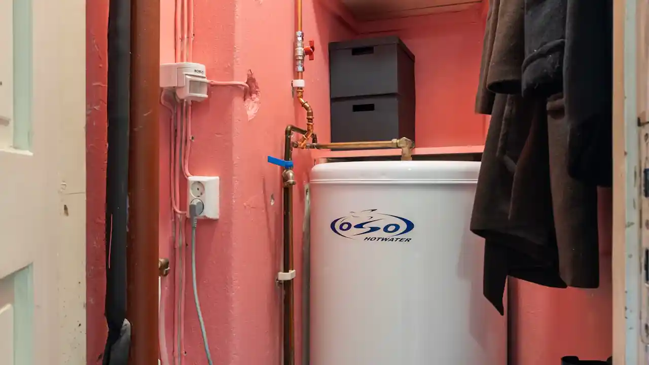 Tank water heater in a closet where leaks pool at the base